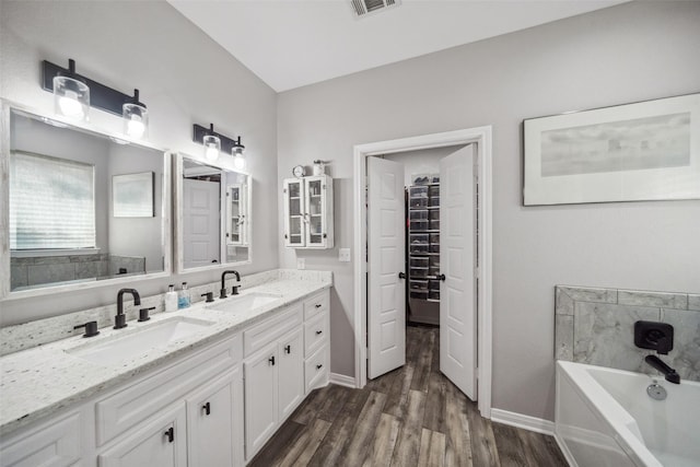 bathroom with vanity, hardwood / wood-style flooring, and a tub