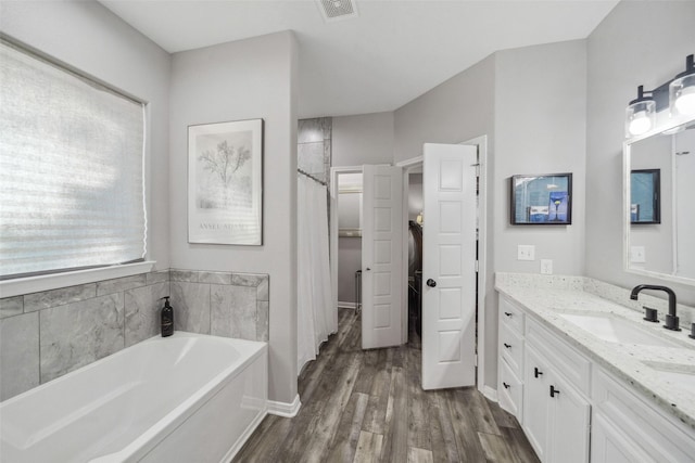 bathroom with vanity, a bath, and hardwood / wood-style flooring