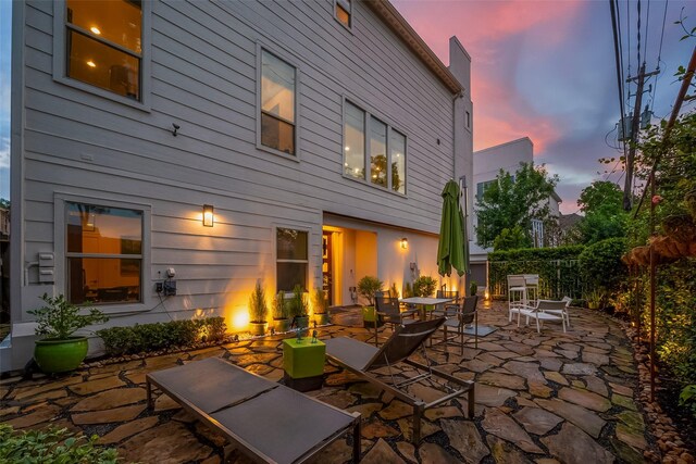 back house at dusk with a patio