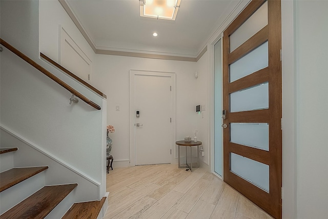 entrance foyer with ornamental molding and light hardwood / wood-style floors