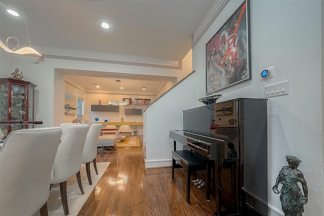 dining space with wood-type flooring and ornamental molding