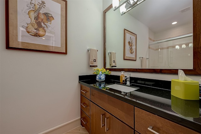 bathroom with tile patterned floors, a shower with door, and vanity