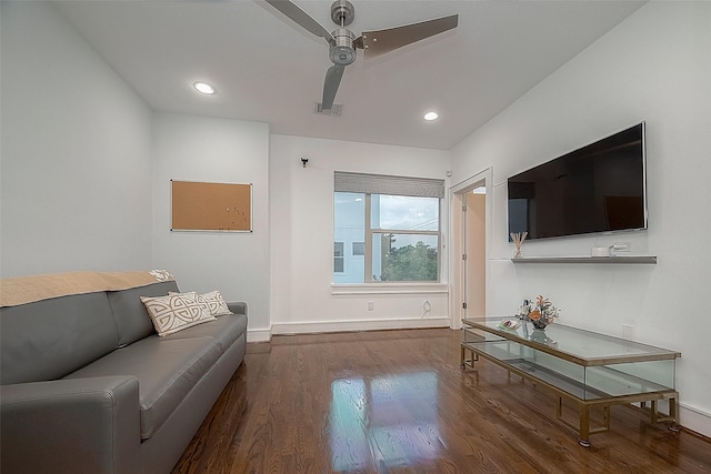 living room featuring ceiling fan and dark wood-type flooring