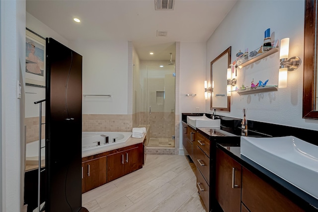 bathroom featuring shower with separate bathtub and vanity