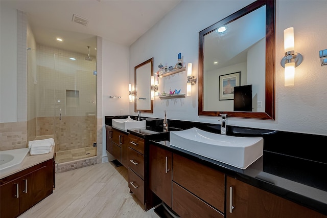 bathroom with a shower with shower door and vanity