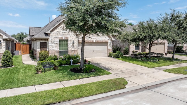 obstructed view of property with fence, stone siding, concrete driveway, roof with shingles, and a front lawn