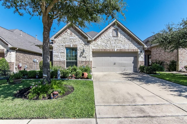 french provincial home with an attached garage, stone siding, concrete driveway, and a front yard