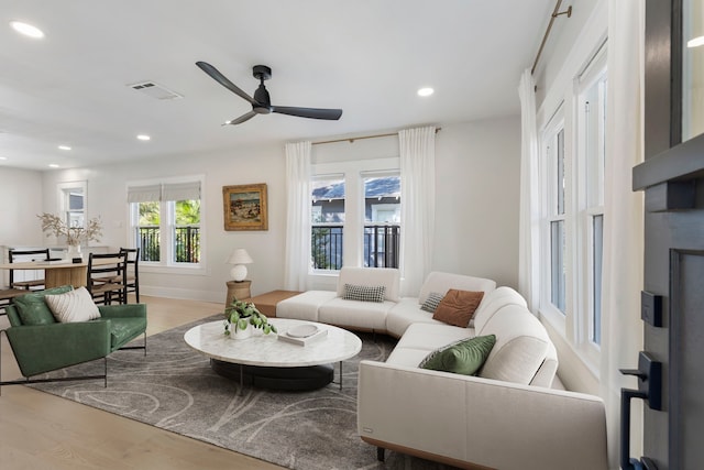 living room with light hardwood / wood-style flooring and ceiling fan