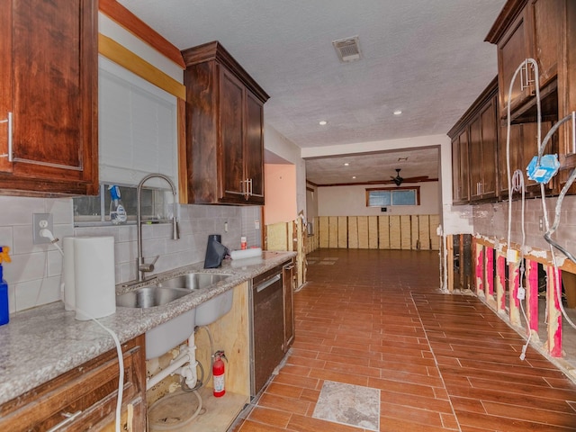 kitchen featuring ceiling fan, sink, light stone counters, stainless steel dishwasher, and decorative backsplash