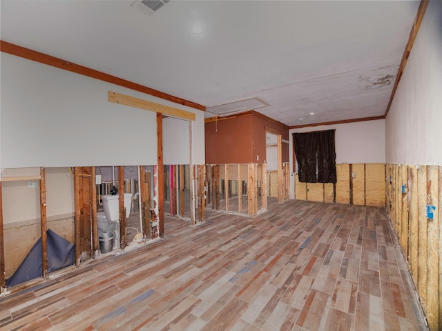 empty room with crown molding and light hardwood / wood-style floors