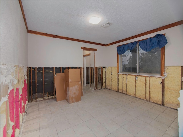 empty room with a textured ceiling and ornamental molding