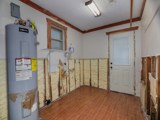 basement with electric water heater and ornamental molding