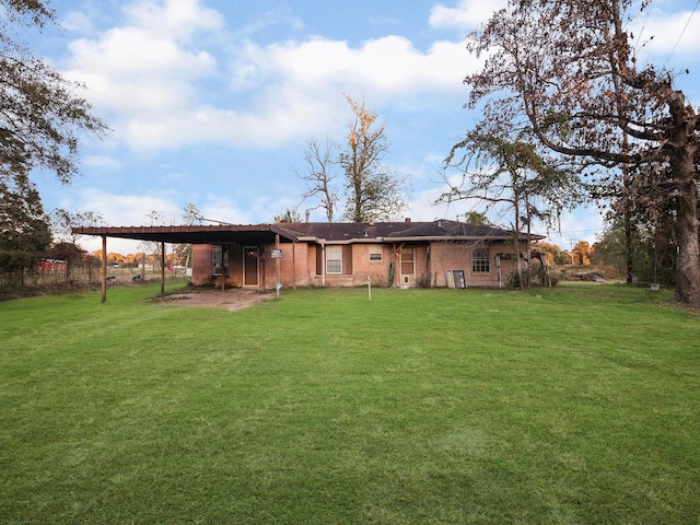 rear view of property featuring a carport and a lawn