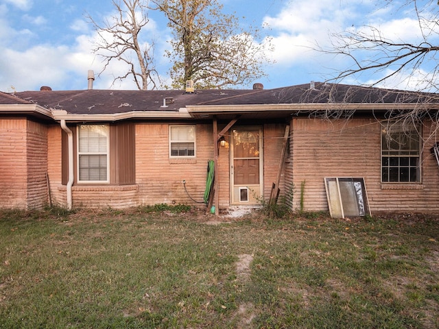 rear view of house featuring a lawn