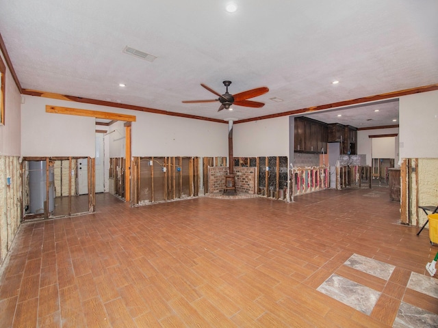 empty room with ceiling fan, a wood stove, and crown molding