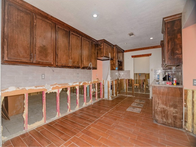 kitchen with ornamental molding and a textured ceiling