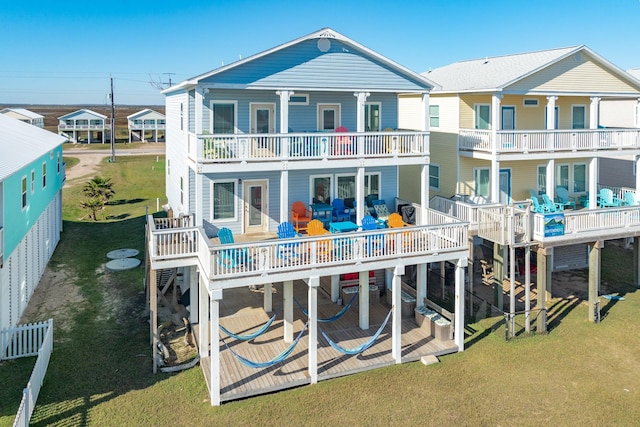 rear view of house with a balcony and a lawn