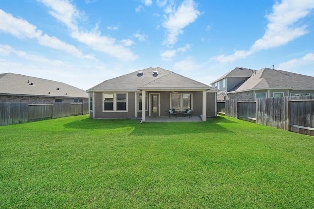 back of house featuring a patio and a yard