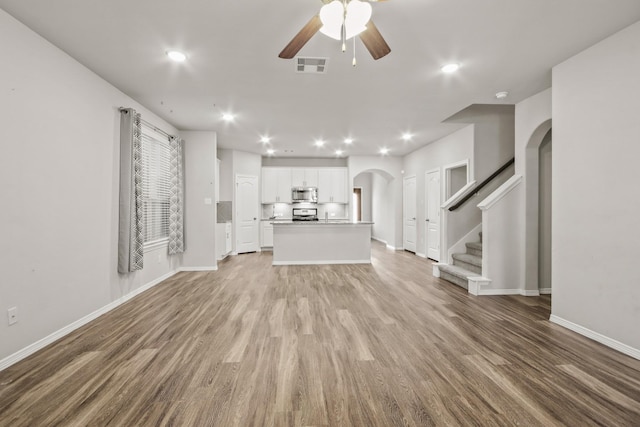 unfurnished living room featuring ceiling fan and light hardwood / wood-style flooring