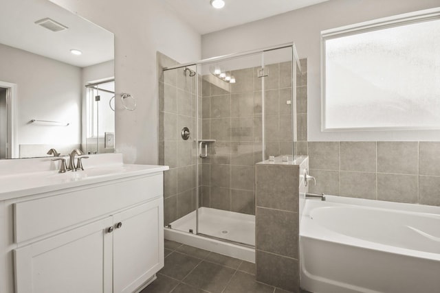 bathroom with tile patterned floors, plus walk in shower, plenty of natural light, and vanity