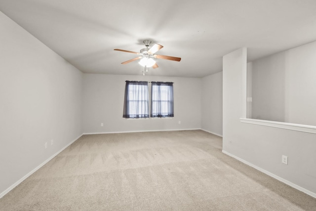 spare room featuring light carpet and ceiling fan