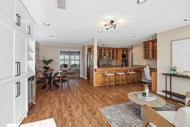 living area featuring dark wood-style floors, baseboards, visible vents, and recessed lighting