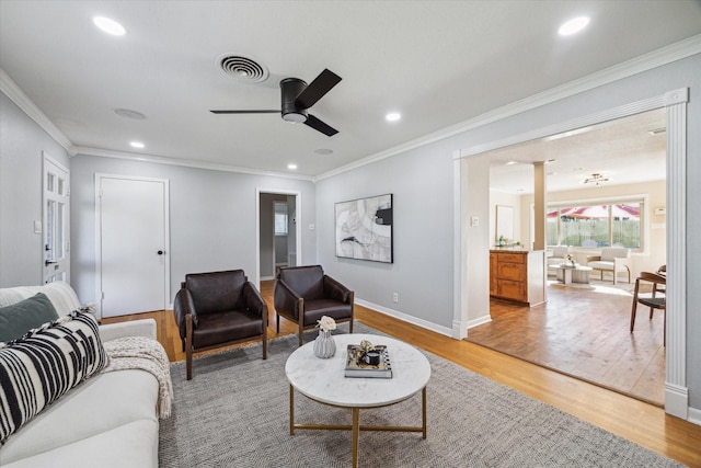 living area with ornamental molding, wood finished floors, visible vents, and recessed lighting