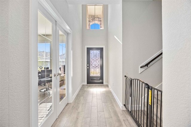 entrance foyer with plenty of natural light, light hardwood / wood-style floors, and french doors