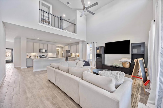 living room featuring ceiling fan and light wood-type flooring