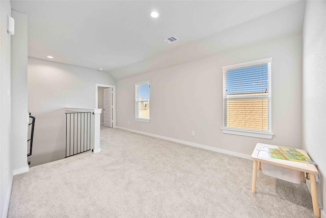 carpeted spare room with lofted ceiling