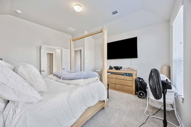 bedroom with vaulted ceiling, light colored carpet, and a closet