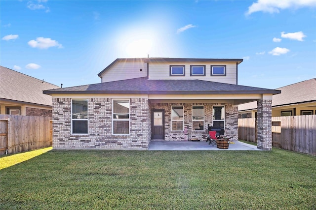 rear view of property with a lawn, a patio, and an outdoor fire pit