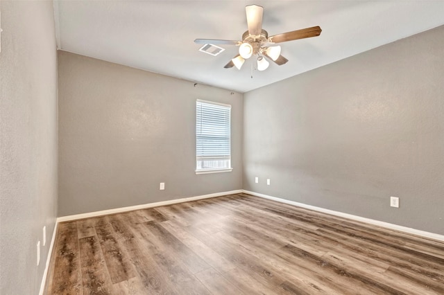 spare room with hardwood / wood-style floors and ceiling fan