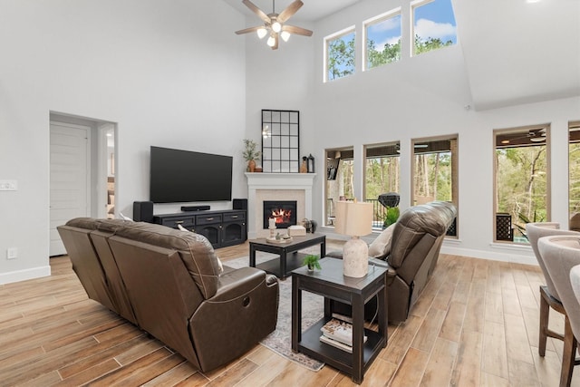 living room featuring ceiling fan and a towering ceiling