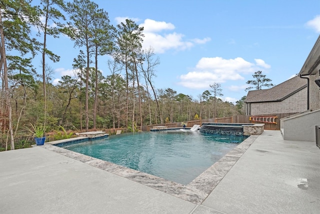 view of pool with pool water feature, a patio area, and an in ground hot tub