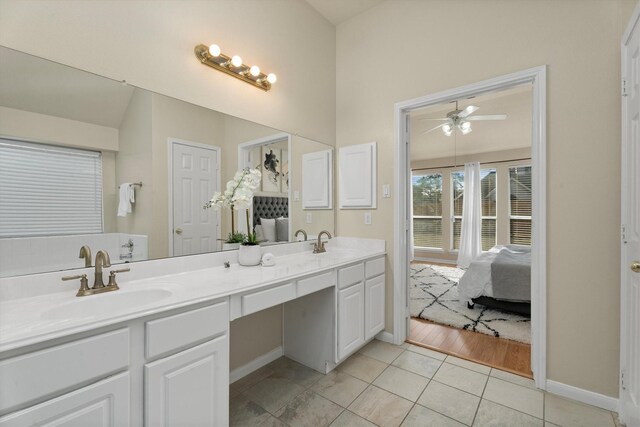 ensuite bathroom with tile patterned flooring, double vanity, connected bathroom, and a sink