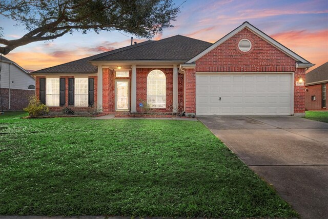 view of front of property featuring a garage and a yard