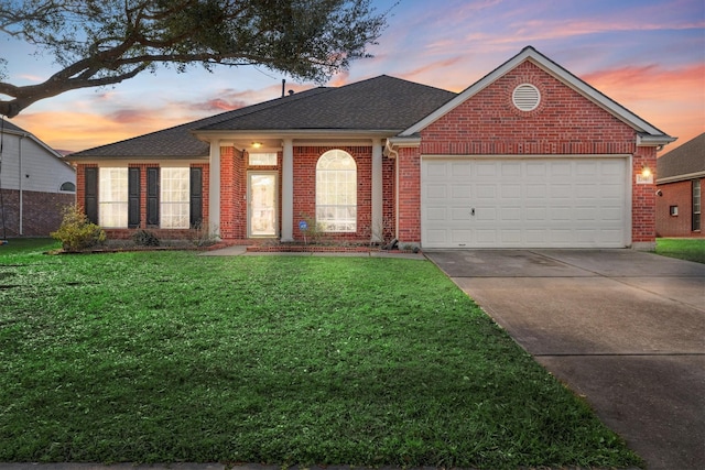 ranch-style home with brick siding, roof with shingles, concrete driveway, a garage, and a front lawn