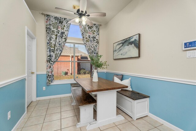 unfurnished dining area with ceiling fan, light tile patterned floors, baseboards, and breakfast area