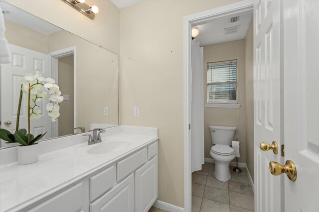 bathroom with vanity, toilet, visible vents, and baseboards