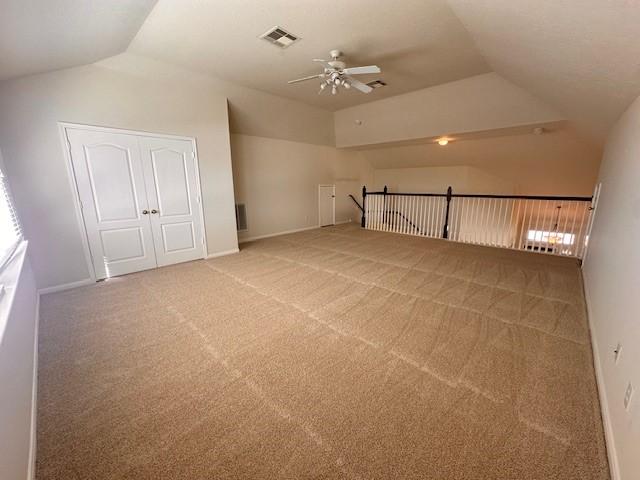 additional living space with carpet flooring, ceiling fan, and vaulted ceiling