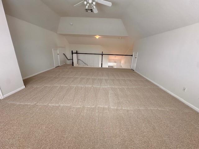 additional living space with light colored carpet, ceiling fan, and lofted ceiling