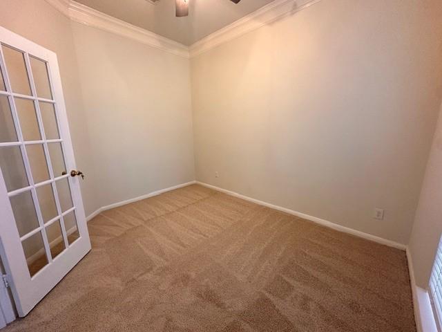 carpeted empty room with ceiling fan and ornamental molding