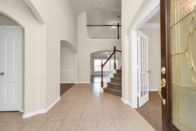 tiled entryway featuring a towering ceiling