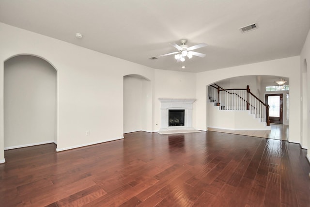 unfurnished living room featuring ceiling fan and dark wood-type flooring