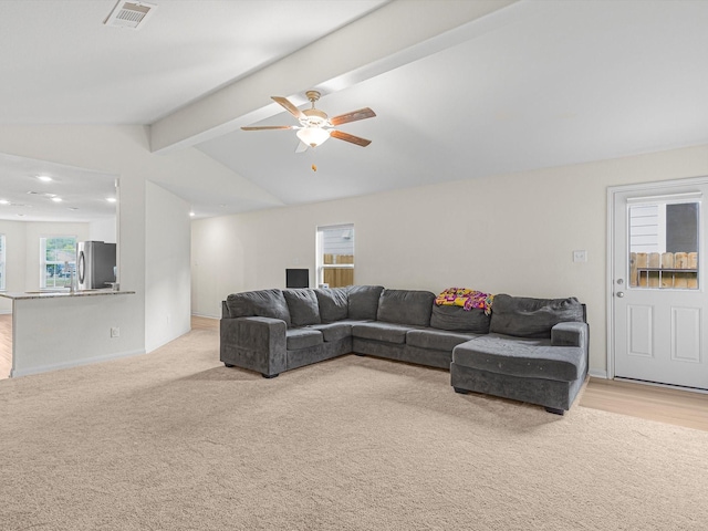 carpeted living room featuring lofted ceiling with beams and ceiling fan