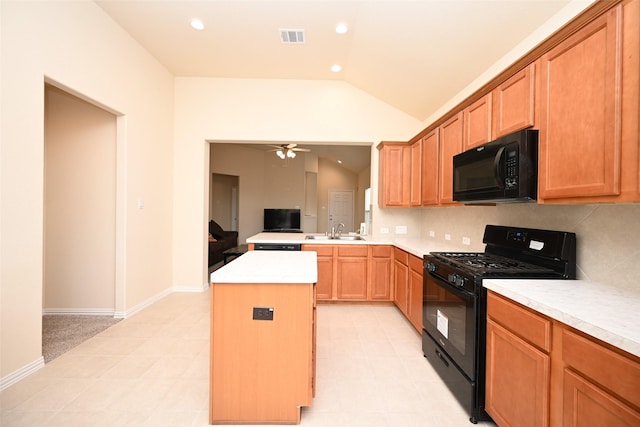 kitchen featuring tasteful backsplash, ceiling fan, sink, black appliances, and a kitchen island