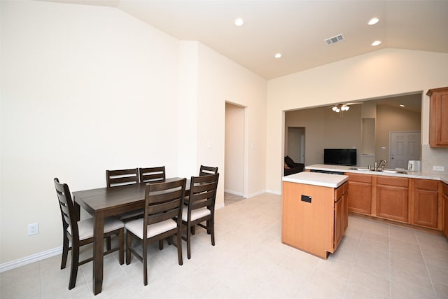 kitchen with a center island, lofted ceiling, sink, ceiling fan, and light tile patterned floors