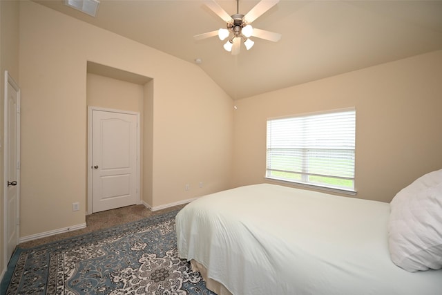 bedroom with dark carpet, ceiling fan, and lofted ceiling