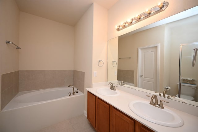 bathroom featuring tile patterned floors, a bathtub, toilet, and vanity